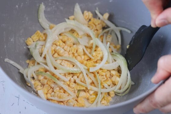 とうもろこしと玉ねぎに薄力粉をまんべんなくまぶす