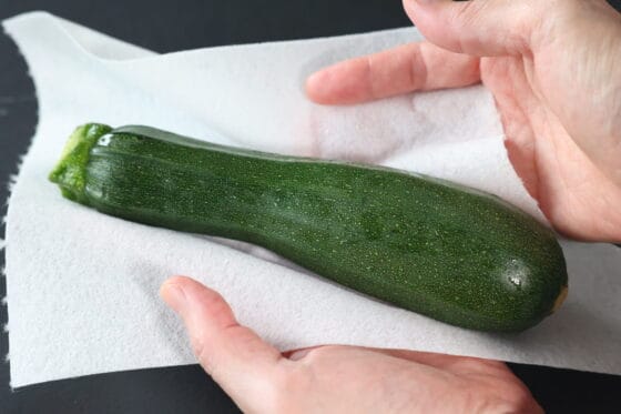 洗ったズッキーニの水気をキッチンペーパーでふき取る