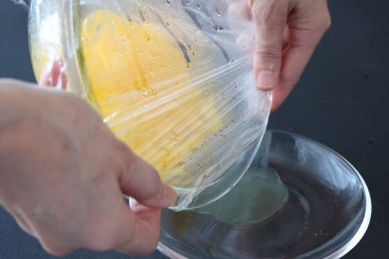 レンジ加熱した黄パプリカの耐熱容器を傾け、余分な水分を軽く切る