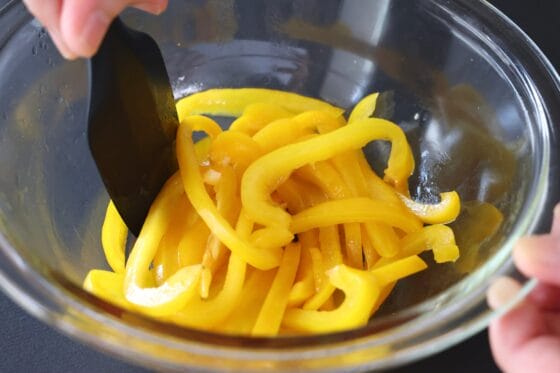 黄パプリカに醤油、ごま油、酢を加えて、熱いうちに全体を和える