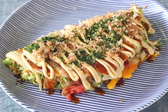 キャベツ焼きにソース、マヨネーズ、鰹節、青のりをかけて仕上げる