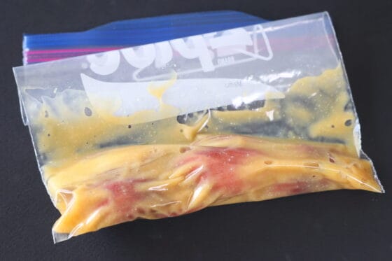 袋の空気を抜き、口を閉じてみょうがの味噌漬けを漬ける