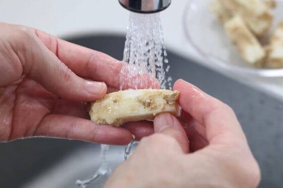 長芋のぬか漬けを水でさっと洗い、表面に付いたぬかを洗い流す