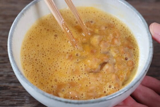 納豆と卵を白身を切るように箸で混ぜ、納豆卵をなめらかに仕上げる