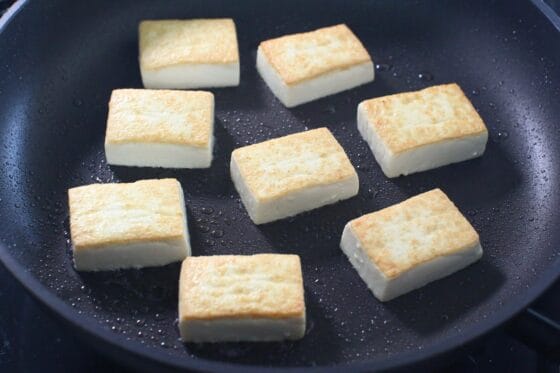 木綿豆腐を返しながら中火で焼き、両面にこんがりと焼き色をつける