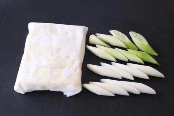 木綿豆腐をキッチンペーパーで水切りし、長ネギを1.5cm幅に斜め切りする