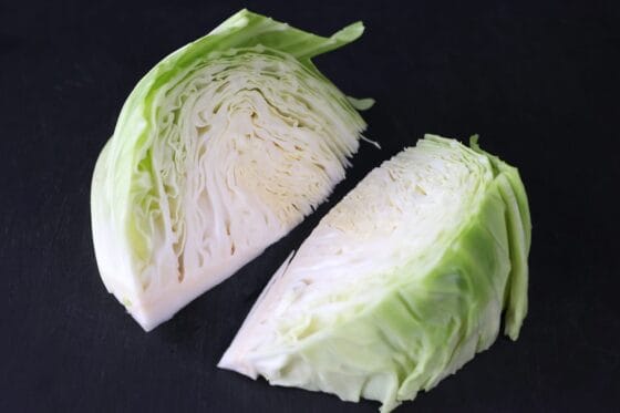 芯を残したキャベツを縦半分のくし形に切る