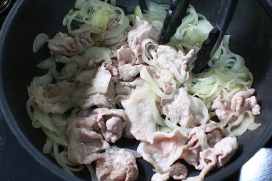 玉ねぎに豚こま切れ肉を加え、肉の色が変わるまで中火で炒める