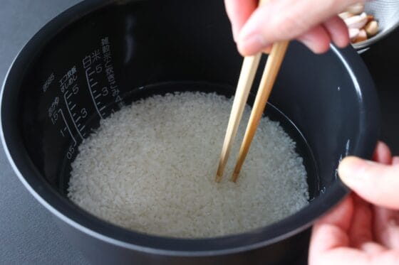炊飯器の内釜に米・塩・酒・水を入れて混ぜる
