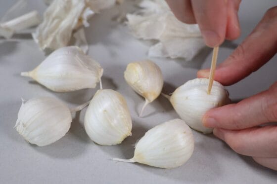にんにくを1片ずつに分け、薄皮を付けたまま爪楊枝で穴をあける