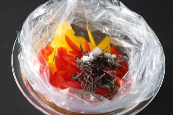 ポリ袋にパプリカと塩昆布、酢、砂糖を入れて浅漬けの準備をする