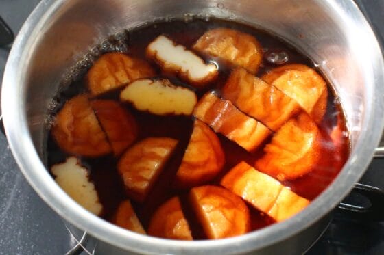 煮立った煮汁にさつま揚げを加えて煮る