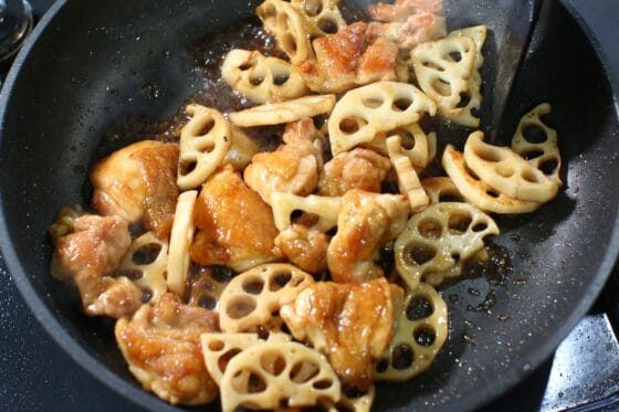 鶏肉とれんこんに甘辛だれを加えて照りが出るまで炒め合わせる
