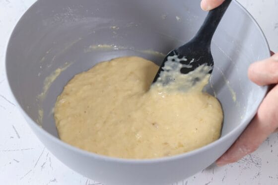 バナナ蒸しパンの生地をゴムベラでさっくり混ぜ、粉っぽさをなくす