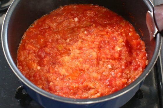 炒めた玉ねぎにカットトマト缶を加え、全体を混ぜ合わせる