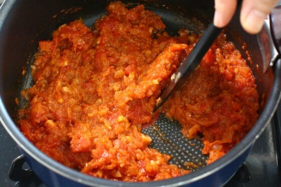 トマトペーストにクミンなどのスパイスと塩を加えて炒め合わせる