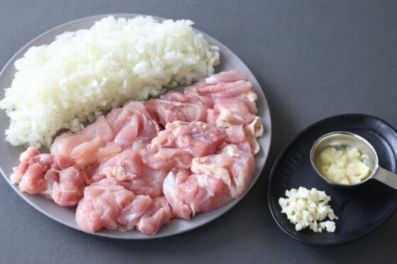鶏もも肉と玉ねぎを切ってにんにくと生姜を用意する