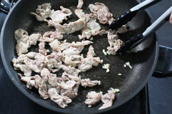 炒めた豚肉に刻んだにんにくを加えて香りを立たせる