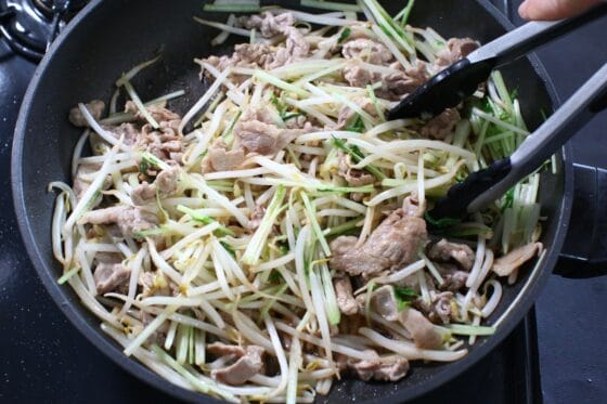 合わせ調味料を絡めながらもやしと水菜の茎を炒める