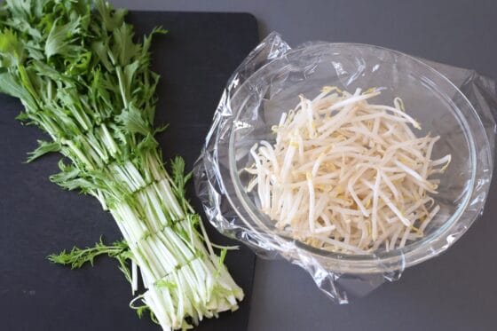 水菜を切り、耐熱容器に入れたもやしにラップをかける