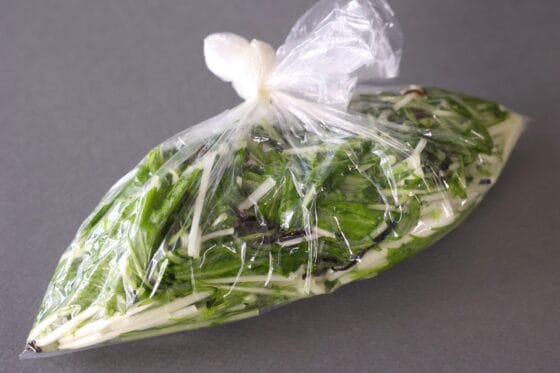 ポリ袋の空気を抜いて口を閉じ、水菜の漬物を漬ける