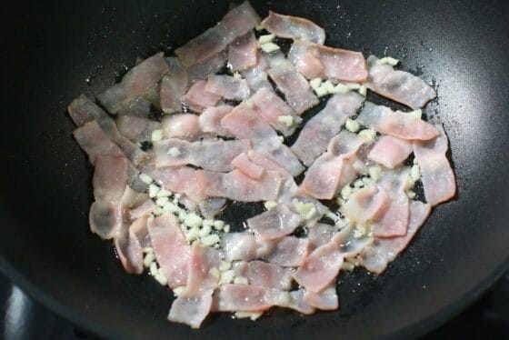 ベーコンをにんにくと一緒に炒め、軽く焼き色をつける