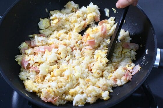 鶏ガラスープの素や醤油などで味を付け、ご飯を炒め合わせる