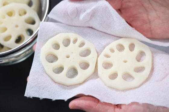 水にさらしたれんこんをキッチンペーパーで挟み、水気をしっかり拭き取る
