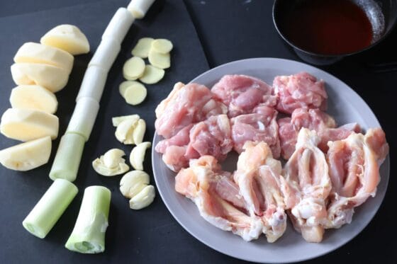 鶏もも肉と手羽元、じゃがいも、長ねぎ、香味野菜を切ってそろえる